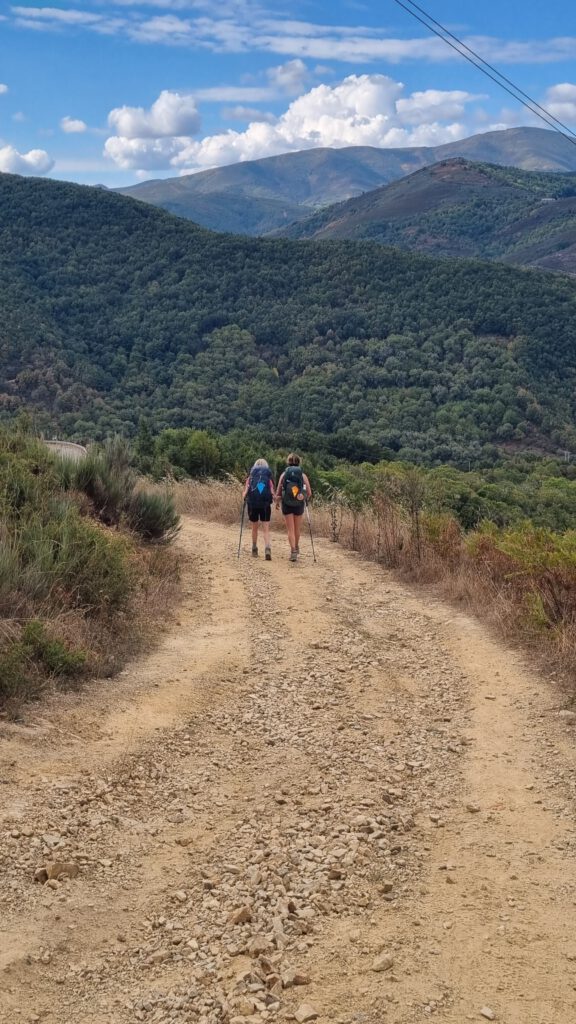 2 wandelaar op een zand en steenpad op weg naar het onbekende.