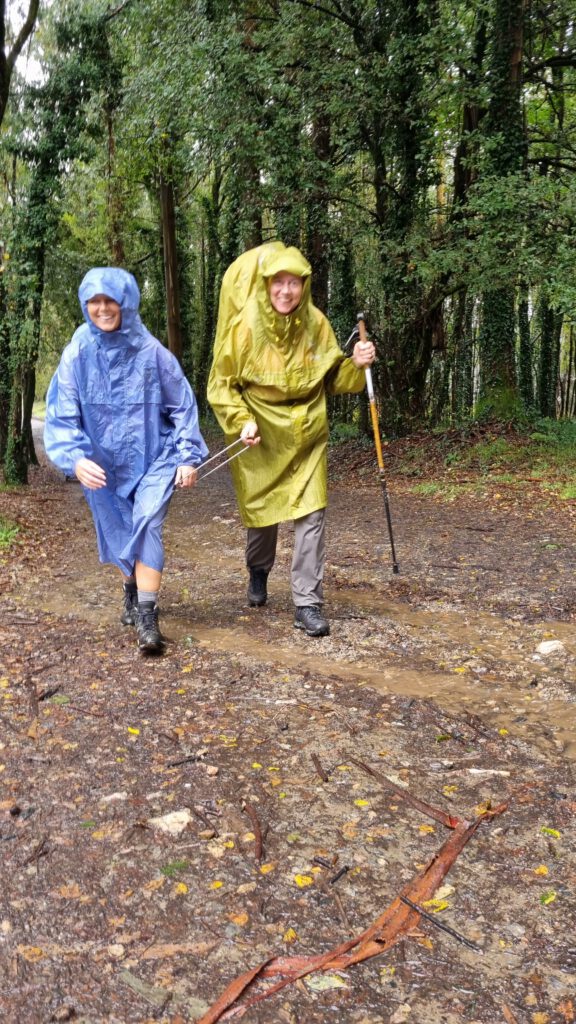 2 wandelaars in de regen met wandelbeugel verbonden